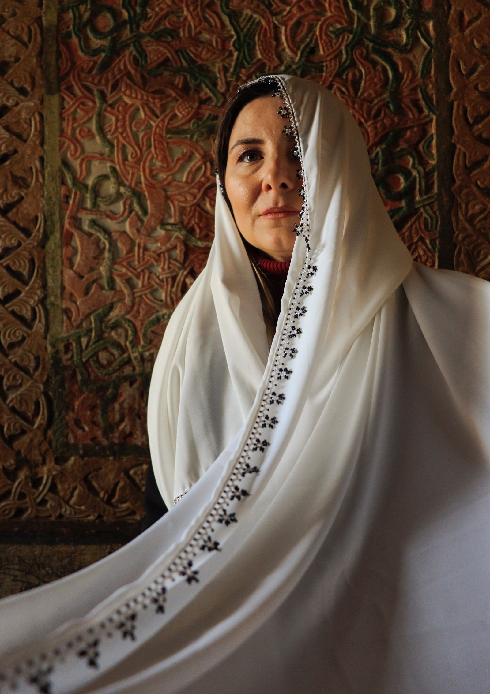 Woman wearing a warm saffron shawl in soft natural light